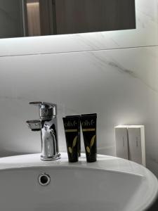 a bathroom sink with two cups and a faucet at Studio Lumo in Nea Moudania