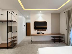 a bedroom with a desk and a tv on the wall at Grand WK Hotel in Yogyakarta