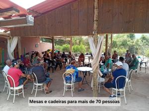 a large group of people sitting in chairs in a patio at Sitio Daniel in Mateus Leme