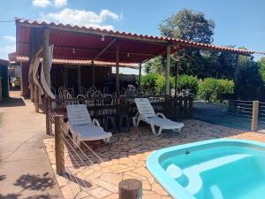 a patio with chairs and a swimming pool at Sitio Daniel in Mateus Leme