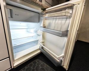 an empty refrigerator with its door open in a kitchen at The Alpine Studio Hideout in Schwanden