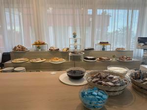 ein Tisch mit vielen Tellern voller Essen in der Unterkunft Hotel Carnaby in Rimini + 12 Fotos