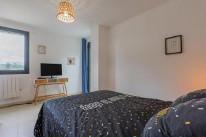 a bedroom with a bed and a television in it at Le Lavoir De Gras - Chambre d'hôte in Gras