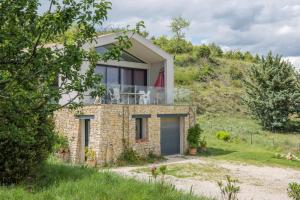 a stone house on a hill with a balcony at Le Lavoir De Gras - Chambre d'hôte in Gras