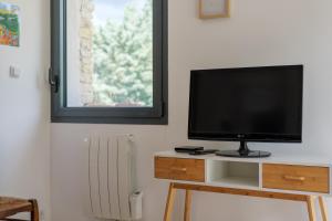 a flat screen tv sitting on a stand in a room at Le Lavoir De Gras - Chambre d'hôte in Gras +11 photos