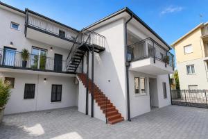 a white house with a staircase on it at Villa Gaspare in Lido di Jesolo