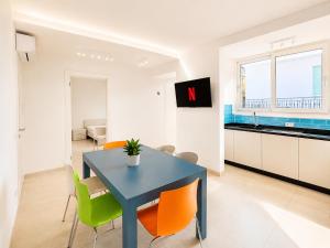 a kitchen and dining room with a blue table and chairs at Villa Gaspare in Lido di Jesolo