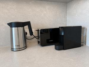 a coffee maker and a microwave on a counter at Pirtelių resort - Mėlynasis namelis in Kiauleikiai