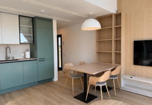 a kitchen and dining room with a table and chairs at Pirtelių resort - Mėlynasis namelis in Kiauleikiai