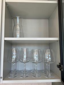 a row of wine glasses in a drawer at Pirtelių resort - Mėlynasis namelis in Kiauleikiai
