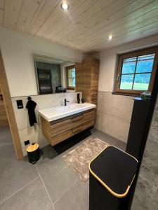 a bathroom with a white sink and a mirror at Ferienwohnung Loifried in Abtenau +46 photos