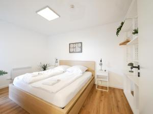 a white bedroom with a large bed with white sheets at 61 m2 Erdgeschosswohnung mit eigenem Parkplatz vorm Haus in Osnabrück