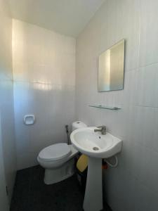 a white bathroom with a toilet and a sink at Villa Peray Siargao in General Luna +20 photos