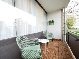 a balcony with two chairs and a table and a window at 61 m2 Erdgeschosswohnung mit eigenem Parkplatz vorm Haus in Osnabrück