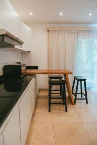 a kitchen with a wooden table and two stools at Hotel Gran David in Santiago