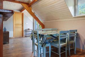a dining room with a blue table and chairs at L'Appartement des Trois Vallées in Villelongue