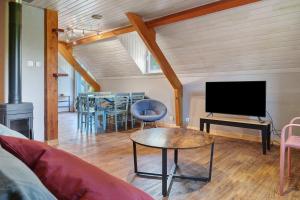 a living room with a couch and a tv and a table at L'Appartement des Trois Vallées in Villelongue