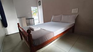 a small bed in a room with a window at JOSEPH'S HOMESTAY in Fort Kochi