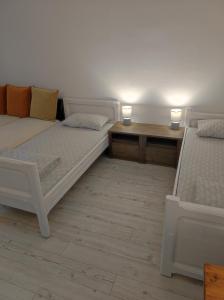 two beds in a room with two tables and two lamps at Chostello Ecomis Clasik in Sibiu