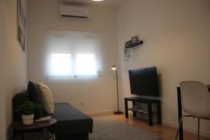 a living room with a couch and a television at TangoSierraResidences in Alcochete