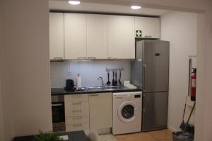 a kitchen with a refrigerator and a washing machine at TangoSierraResidences in Alcochete