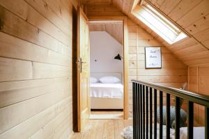 a small attic room with a bed and a staircase at TDI - Modern 2-Bedroom Apartment in nature in Kanji Dol