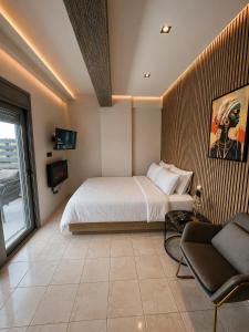 a bedroom with a bed and a couch and a tv at Luxury Black and White Interior Apartments & Rooftop Terrace in Kalamata