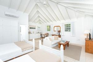 a white living room with a bed and a couch at Gibbs Cottages in Saint Peter