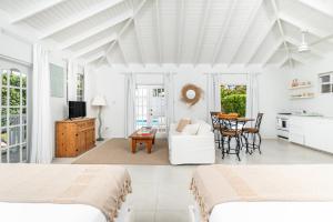 a white room with two beds and a table at Gibbs Cottages in Saint Peter +8 photos