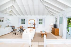 a living room with a white couch and a table at Gibbs Cottages in Saint Peter