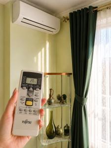 a person holding a remote control in a room at Apartament Pers - komfortowy relaks przy kominku i klimatyzacji in Szczawno-Zdrój