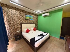 a bedroom with a bed with a green wall at Sabbia Rossa Beach Resort in Arambol