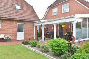 a house with a patio with a table and chairs at Ferienwohnung Sonnenberg, 25502 in Weener