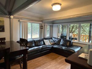 a living room with a leather couch and a table at Spa Lake & Miller Zoo - Oppy Shack in Frampton +16 photos