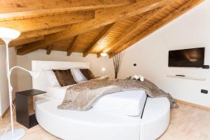 a white bedroom with a white bed and a tv at AcquaTerraFuoco - City Apartments in Como
