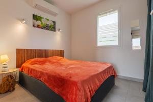a bedroom with a bed with a orange blanket on it at Résidence Château Saint Martin in Saint-Martin-dʼArdèche