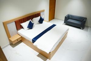 a bedroom with a large bed and a chair at Shalini Residency in Nalgonda