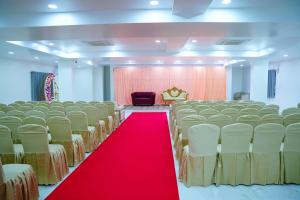 a banquet hall with a red carpet and chairs at Shalini Residency in Nalgonda