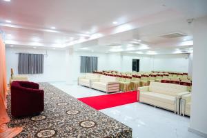a conference room with white chairs and a red carpet at Shalini Residency in Nalgonda +21 photos