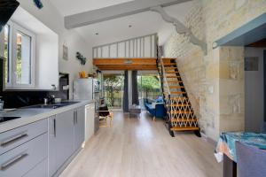 a kitchen with a staircase in the middle of a room at Gîte de la Barrière in Sainte-Gemme