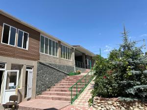 a house with stairs leading up to a building at Guest House Arbat in Cholpon-Ata
