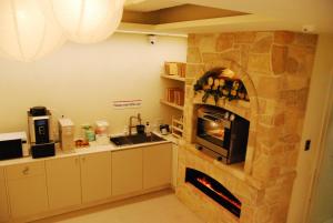 a kitchen with a stone fireplace in a room at 굿데이 큐브 캡슐 호텔 in Busan