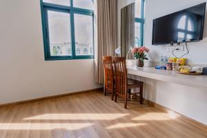 a room with a desk with a chair and a window at Viona Beach Hotel - Marina Phu Quoc in Phú Quốc