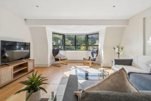 a living room with a couch and a tv at Windsor Castle Views - Spacious Flat - By Tempstay in Windsor