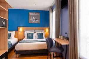 a hotel room with a bed and a desk at Grand Hotel Dore in Paris