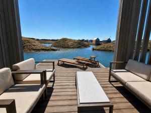 a porch with couches and a view of the water at Pirtelių resort - Pilkasis namelis in Kiauleikiai