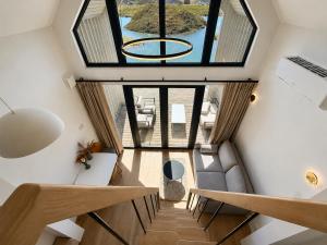 a view from the loft of a house with a large window at Pirtelių resort - Pilkasis namelis in Kiauleikiai