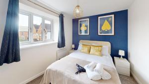 a bedroom with blue walls and a bed with towels on it at Buckland Mews in Abingdon
