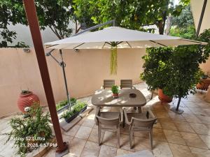 a table and chairs under an umbrella on a patio at HOME SWEET HOME in Chios