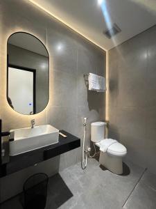 a bathroom with a sink and a toilet and a mirror at Grand WK Hotel in Yogyakarta +15 photos